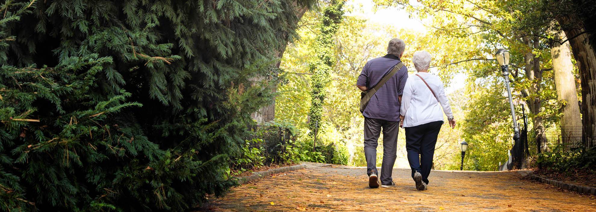 Older couple walking through park